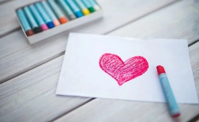 a heart drawn on a piece of paper with a red crayon