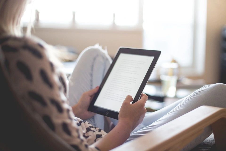 a woman reading something on a tablet