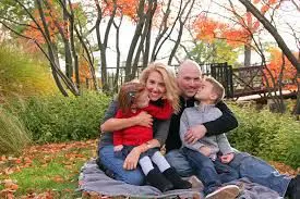 a couple with two kids sitting on the lawn